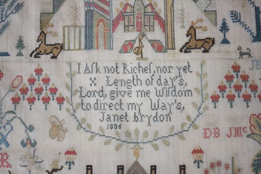 A George lll needlework sampler dated 1806, by Janet Brydon. Worked on fine linen, the sampler embroidered with ornate motifs of angels, birds, deer, lions and a castle around a short embroidered script; I ask not riches